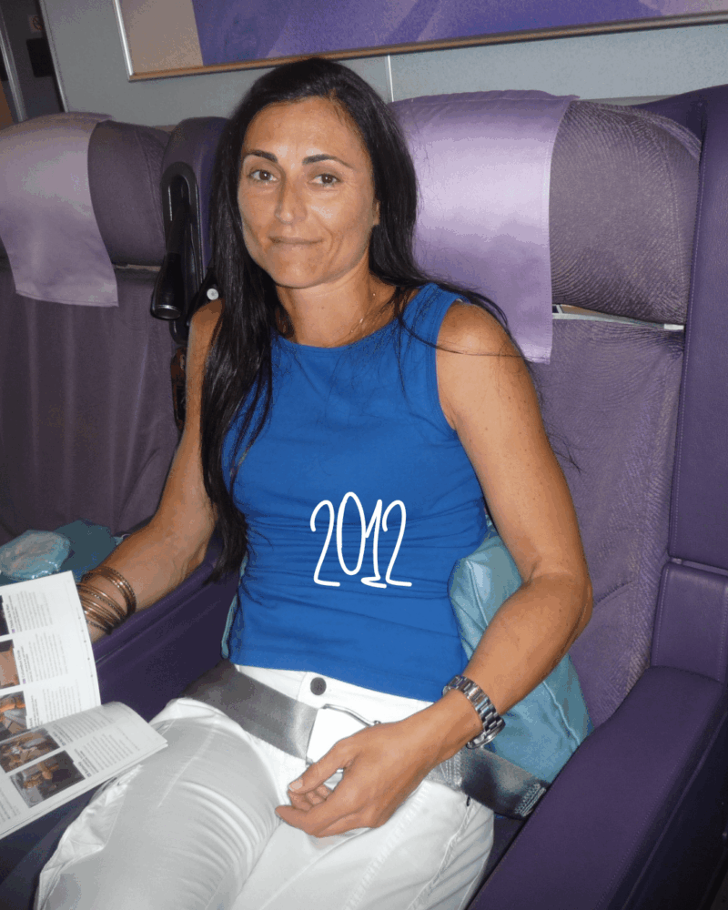 travel_styletips_styleculture_styling_19 woman wearing bright blue top and white pants sitting in an aeroplane business class seat