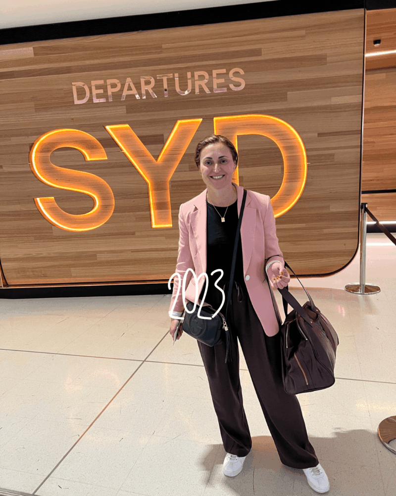 travel_styletips_styleculture_styling_6 airport departure featuring a pink blazer, brown top and pants with a trendy carry-on bag