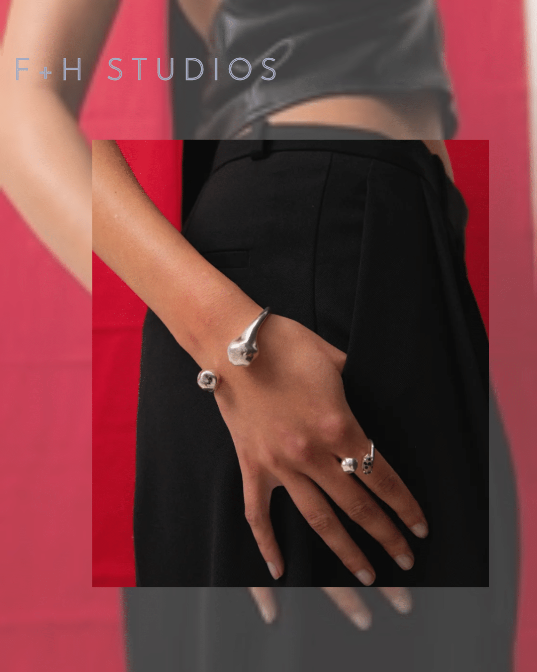 F+H Studios silver hammered wrist cuff with sculptural open-ended design, worn on the wrist.